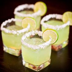 three margaritas with lime and salt garnish on the rim, sitting in small glasses