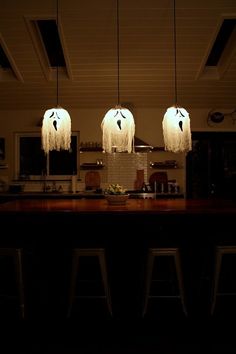 three lights hanging from the ceiling in a kitchen