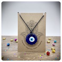 This glass Evil eye pendant necklace would make a wonderful gift for anyone needing a little help in life.  The glass pendant measures approximately 3cm in diameter and is made from layered glass to form the eye.  Every piece is hand made and each unique, with its own appearance, shape and imperfections. The eye is threaded onto silk cord with sliding adjustment knots to each side. The cord measures approximately 40 inches in length so the necklace can be worn long or short. Each necklace is per Tarot Gifts, Glow Jewelry, Glass Evil Eye, Eye Pendant Necklace, Necklace Packaging, Hamsa Bracelet, Protection Amulet, Hippie Necklace, Blue Evil Eye