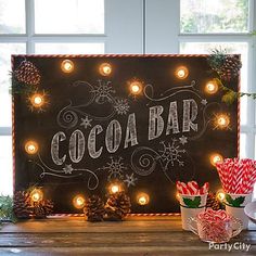 a sign that says cocoa bar with candy canes in front of it and christmas decorations