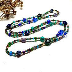 This 42 inch Boho necklace is adorned with an array of stunning glass beads in blue, green and purple shades with antique copper and ceramic accent beads. With no hassle of fastenings, simply pop this beaded necklace over your head and you are good to go! Your new handcrafted accessory will be presented beautifully in a box with soft cotton padding and a description of the bought creation on a gold foiled card, designed to make a memorable gift experience. Wear it with: Please visit my shop for similar items and many more handmade gift ideas, enjoy! https://www.etsy.com/uk/shop/shaziamariamartisan/ Bohemian Glass Long Necklace For Gift, Bohemian Glass Long Necklace Gift, Handmade Glass Long Necklace For Gift, Beaded Glass Long Necklace As A Gift, Blue Long Necklace With Colorful Beads As A Gift, Blue Long Necklace For Gift, Blue Beaded Long Necklace For Gift, Blue Beaded Long Necklace As Gift, Bohemian Long Necklace With Faceted Beads As Gift