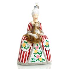 a glass ornament with a woman holding a cat sitting on top of a circus tent