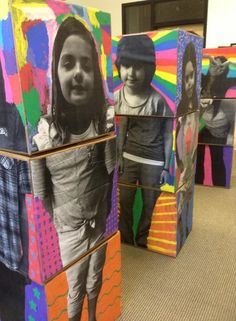 three cardboard boxes with pictures of children on them, all stacked up in the shape of cubes