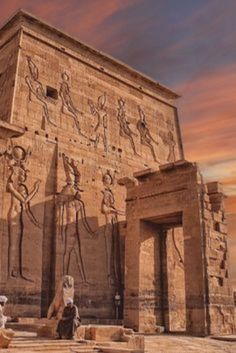 an ancient egyptian temple with statues on the outside