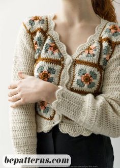 a close up of a person wearing a sweater with flowers on the front and sleeves