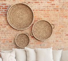 three woven baskets on the wall above a couch