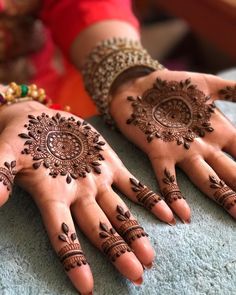 two hands with henna designs on them