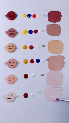 a person holding a paintbrush in front of several different colors of paint on a white board