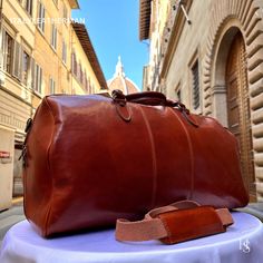 This Italian leather travel bag is expertly handcrafted in Florence, Italy, using the finest genuine leather. Designed for men seeking premium quality, luxury, and modern Italian fashion. Elevate your style with this exquisite accessory. . Size: Height: 30 cm (11.81 inches) Depth: 53 cm (20.87 inches) Width: 26 cm (10.24 inches) . The story of this travel bag: In the heart of Italy, where the rich legacy of craftsmanship thrives, there existed a renowned workshop dedicated to creating exquisite travel accessories. Among their coveted collection were the handmade duffle bags, carefully crafted to cater to the needs of discerning travelers seeking both style and functionality. These duffle bags, designed specifically as men's travel gear, embodied the essence of Italian travel bags. The arti High-end Leather Travel Bag For Everyday Use, High-end Leather Travel Bag, Designer Leather Duffle Bag With Large Capacity, High-end Leather Rectangular Travel Bag, High-end Rectangular Leather Travel Bag, Elegant Cognac Travel Bag For Business, Elegant Cognac Travel Bag With Luggage Sleeve, Elegant Brown Duffle Bag With Large Capacity, Designer Leather Briefcase With Large Capacity