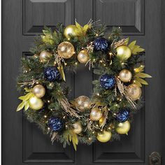 a christmas wreath on a door with ornaments hanging from the front and side panels,