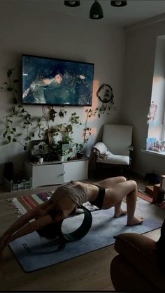 a woman is doing yoga in her living room