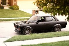 an old car parked on the side of the road with it's hood open