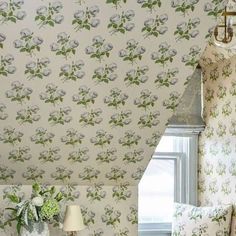 a bedroom with floral wallpaper and white bedding