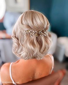 the back of a woman's head wearing a hair comb with pearls on it