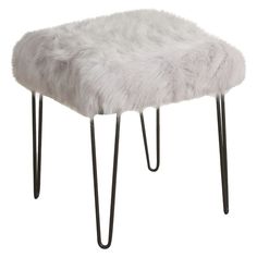 a white stool with metal legs and a furry seat cover on it's back