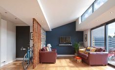 a living room filled with furniture and a bike parked in front of a window on the wall