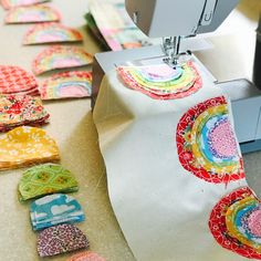 a sewing machine is working on some colorful pieces of fabric that have been sewn together