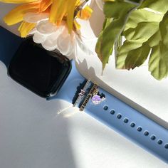 an apple watch sitting next to a flower