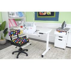 a chair and sewing machine in a room with green walls, rugs and white furniture