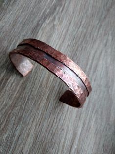 a close up of a metal bracelet on a wooden surface