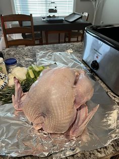 a whole chicken sitting on top of a piece of tin foil