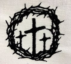 the cross and crown of thorns is embroidered onto a white shirt with black thread