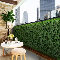 a living room with a large green wall next to a white table and two stools