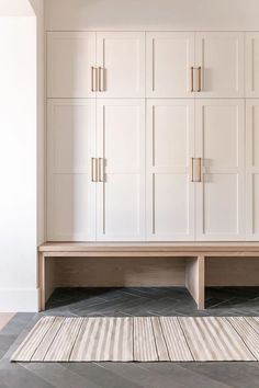 a room with white cupboards and rug on the floor