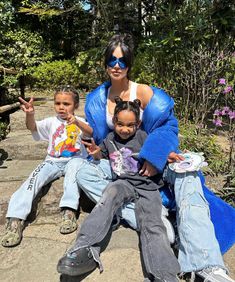 a woman and two children sitting on some steps