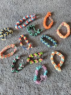 several different colored bracelets laying on the floor next to each other and one has an earring