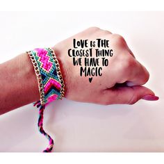 a woman's hand with a bracelet that says love is the closest thing we have to magic