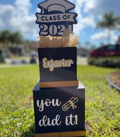 two graduation signs are stacked on top of each other in the middle of some grass