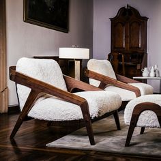 a living room with two chairs and a ottoman