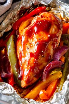 chicken and vegetables in foil with ketchup on top