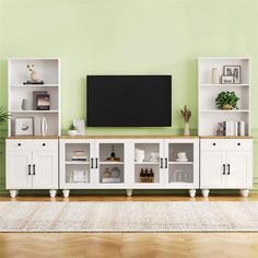 a living room with green walls and white bookcases in front of a flat screen tv