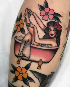 a woman sitting in a bathtub with flowers on her head and legs tattoo design