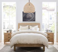 a bedroom with white walls and wooden furniture