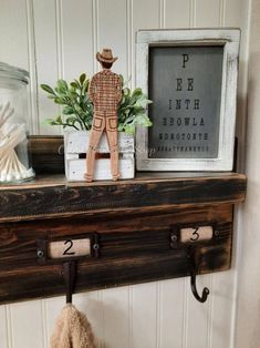 a coat rack with two hooks and a teddy bear on it next to a framed photograph