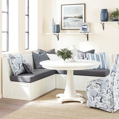 a living room with blue and white furniture on the floor, couches and chairs