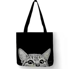 a black and white photo of a cat's face on a tote bag