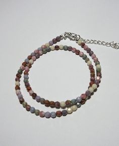 This pastel Czech beaded choker is made with multicolored faceted 4mm rounds. The colors range from light purple to beige, pink, gray and white. The necklace is 16 inches long and has a 2 inch silver plated extender. The pictures do not do it justice. This choker will be slipped into an organza bag and shipped in a bubble mailer. Lavender Beaded Necklace With Faceted Round Beads, Adjustable Multicolor Faceted Beads Choker, Multicolor Polished Bead Choker, Adjustable Multi-strand Purple Beaded Necklaces, Pink Multi-strand Faceted Bead Necklace, Multicolor Necklace, Tiny Beads, Blue Sodalite, Bubble Mailer