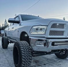 a large silver truck parked on top of snow covered ground