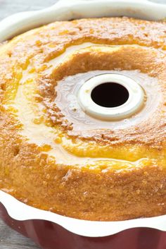 a bundt cake in a red pan with white icing and a black center