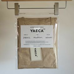 the yaeca t - shirt is on display in a plastic bag with a hanger