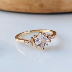 a gold ring with an oval cut diamond surrounded by small white and light brown diamonds