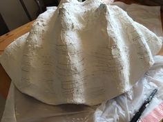 a large white sculpture sitting on top of a table next to a piece of paper