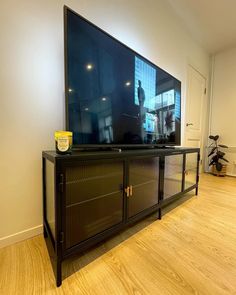 a flat screen tv sitting on top of a wooden cabinet