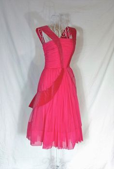 This gorgeous 1950s vintage pink dress is a sleeveless gown with velvet details and the skirt has three layers of pink: crinoline, satin, and a sheer pink layer on top (chiffon?). It has a metal zipper down the back. It is in excellent vintage condition with only one spot noted (see Pink Tulle Cocktail Evening Dress, Pink Sleeveless Evening Dress With Pleated Bodice, Pink Pleated Bodice Evening Dress For Party, Fitted Pink Tea Length Evening Dress, Fitted Pink Tea-length Evening Dress, Vintage Pink Ball Gown Dress, Pink Evening Dress For Cocktail And Prom Season, Pink Evening Dress For Cocktail Prom Season, Pink Pleated Bodice Evening Dress For Cocktail