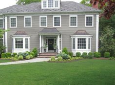 a large gray house with white trim and windows