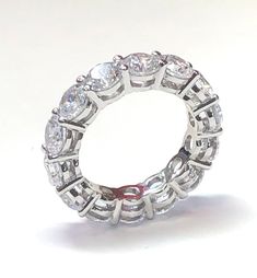 Our eternity band is a showstopper. Featuring round brilliant cut prong set cubic zirconia stones. Wear the band solo or stack with other rings, either way the look is luxurious. See our other bands for stacking. half sizes available. The ring on the right is also available. Item Details: TCW: 4.8 Style: Eternity Band Alternate Style: Cocktail Gender: Women's Stone Color: Clear Stone Cut: Round Stone Size: 4.5 mm Stone Material: Cubic Zirconia Stone Setting: Prong Ring Dimensions: 22 mm x 4.5 mm Dazzling Eternity Band With Prong Setting, Dazzling Round Eternity Band With Prong Setting, Promise Ring Eternity Band With Prong Set Moissanite, Moissanite Eternity Band With Prong Setting For Promise Ring, Lab Grown Diamond Eternity Band With Prong Setting, Dazzling Lab-grown Diamond Eternity Band, Round Cubic Zirconia Ring Channel Set, Cubic Zirconia Channel Set Round Ring, Prong Setting Diamond White Eternity Band